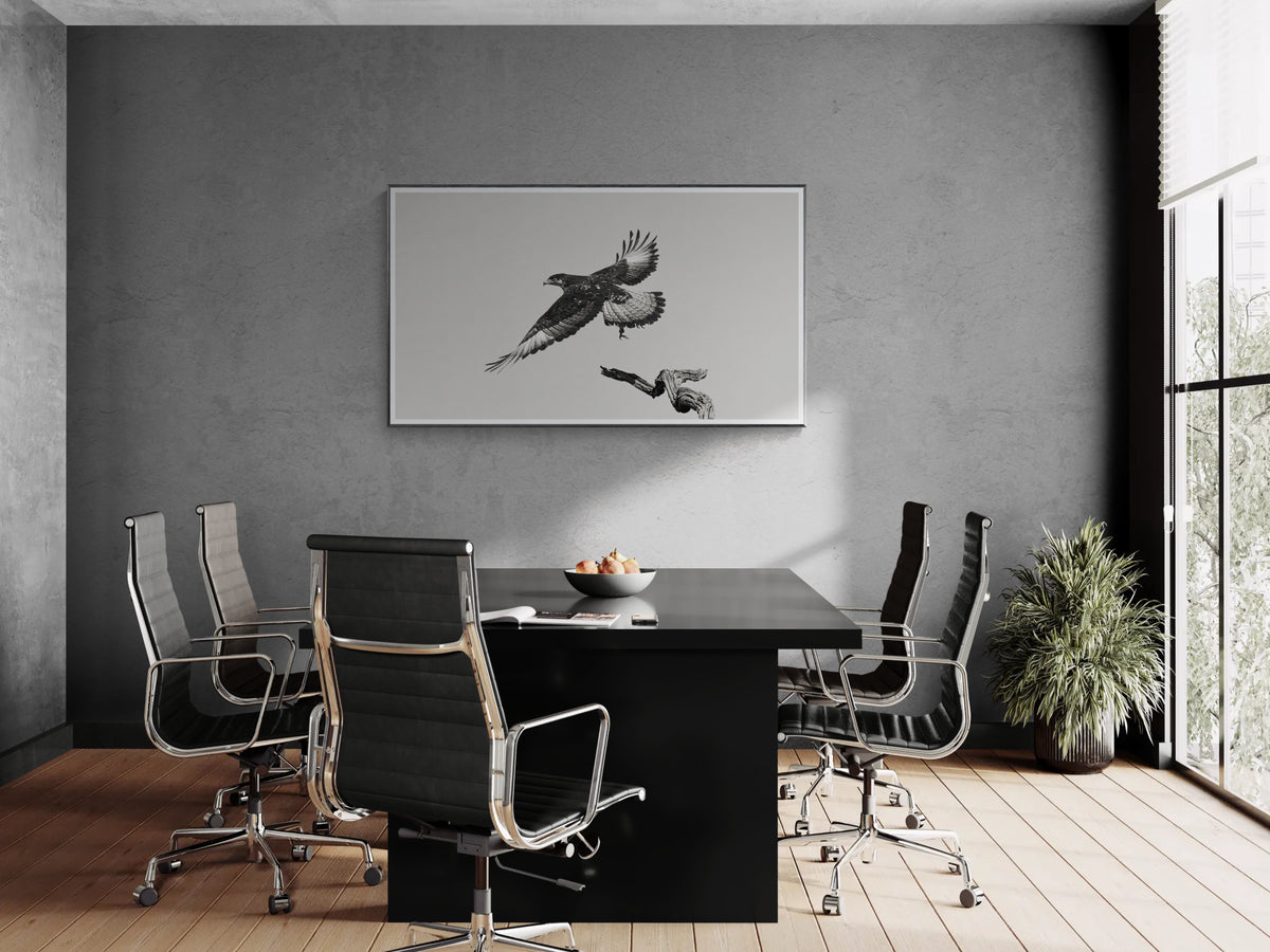 A black and white framed wall fine art print depicting an eagle, displayed in a modern grey office conference room.