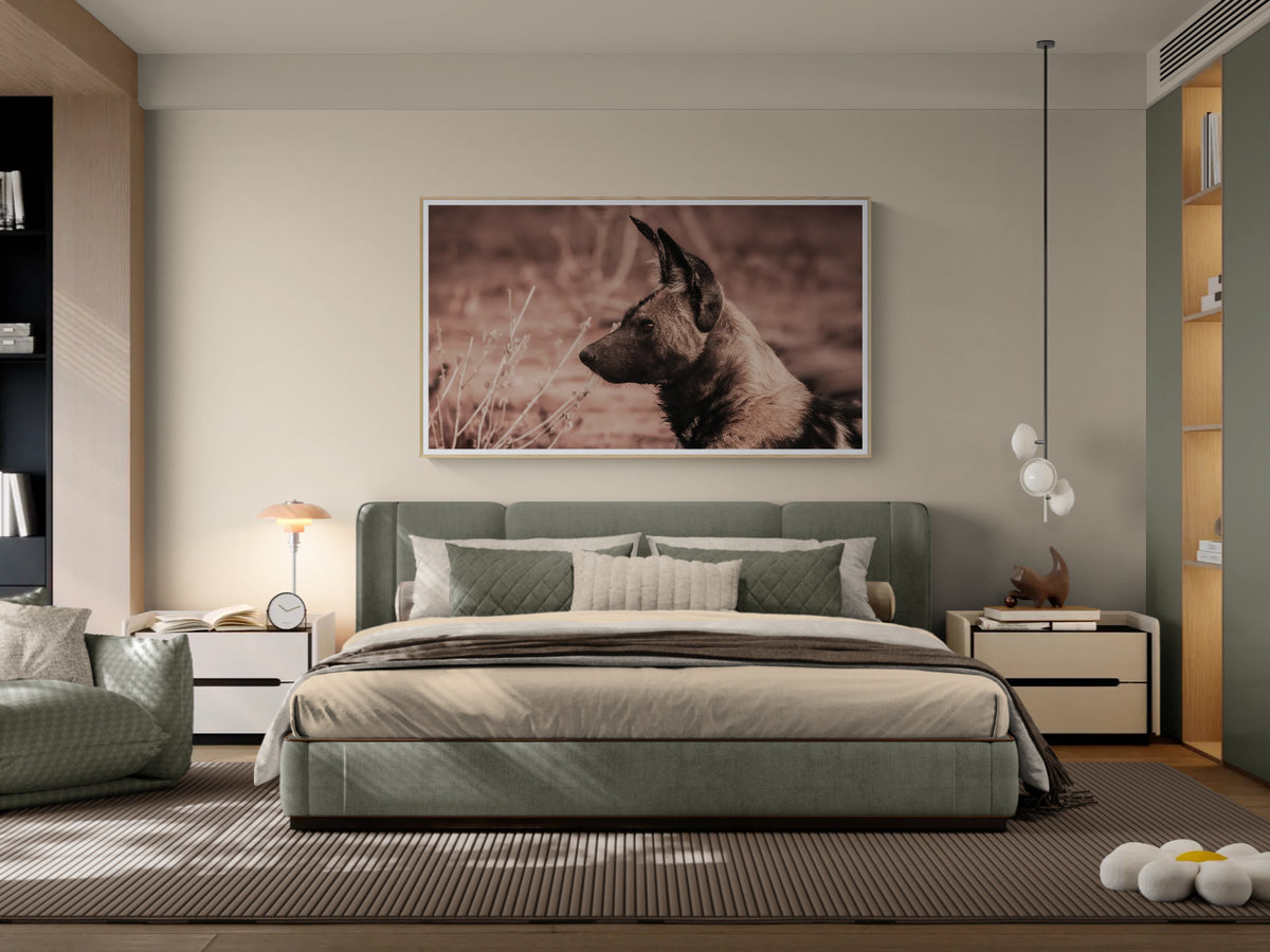 A modern bedroom featuring a large framed wall fine art print of a wild dog in profile, hung above a bed with green and beige bedding.